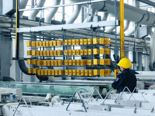 Employee operates the transport crane in an anodising system