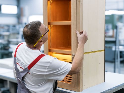 An joiner checks the gap dimensions on the door of a humidor