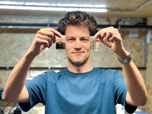 Aymar de Lichtervelde holds two water samples in his hands.